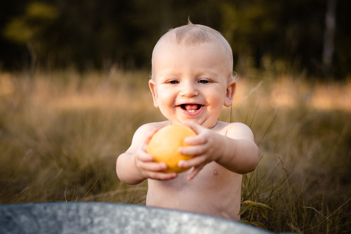 Baby loves lemon in outdoor family photo in Toronto
