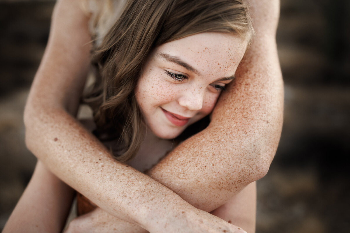 freckled girl wrapped in mamas freckled arms