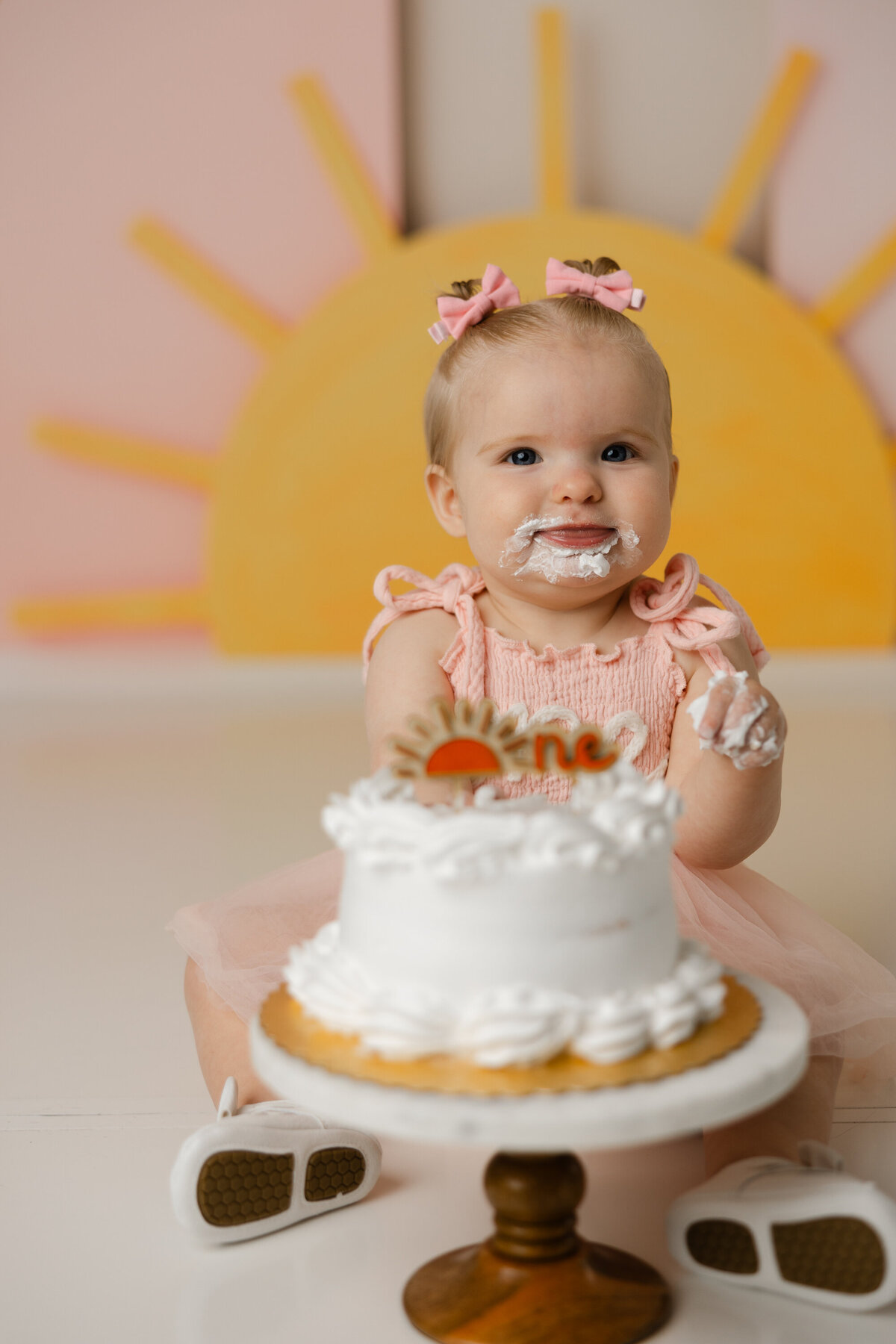 She brought all the sunshine to her cake smash session complete with frosting-covered giggles and golden memories. Captured in Yucaipa by Kaitlyn Dawn Photography.