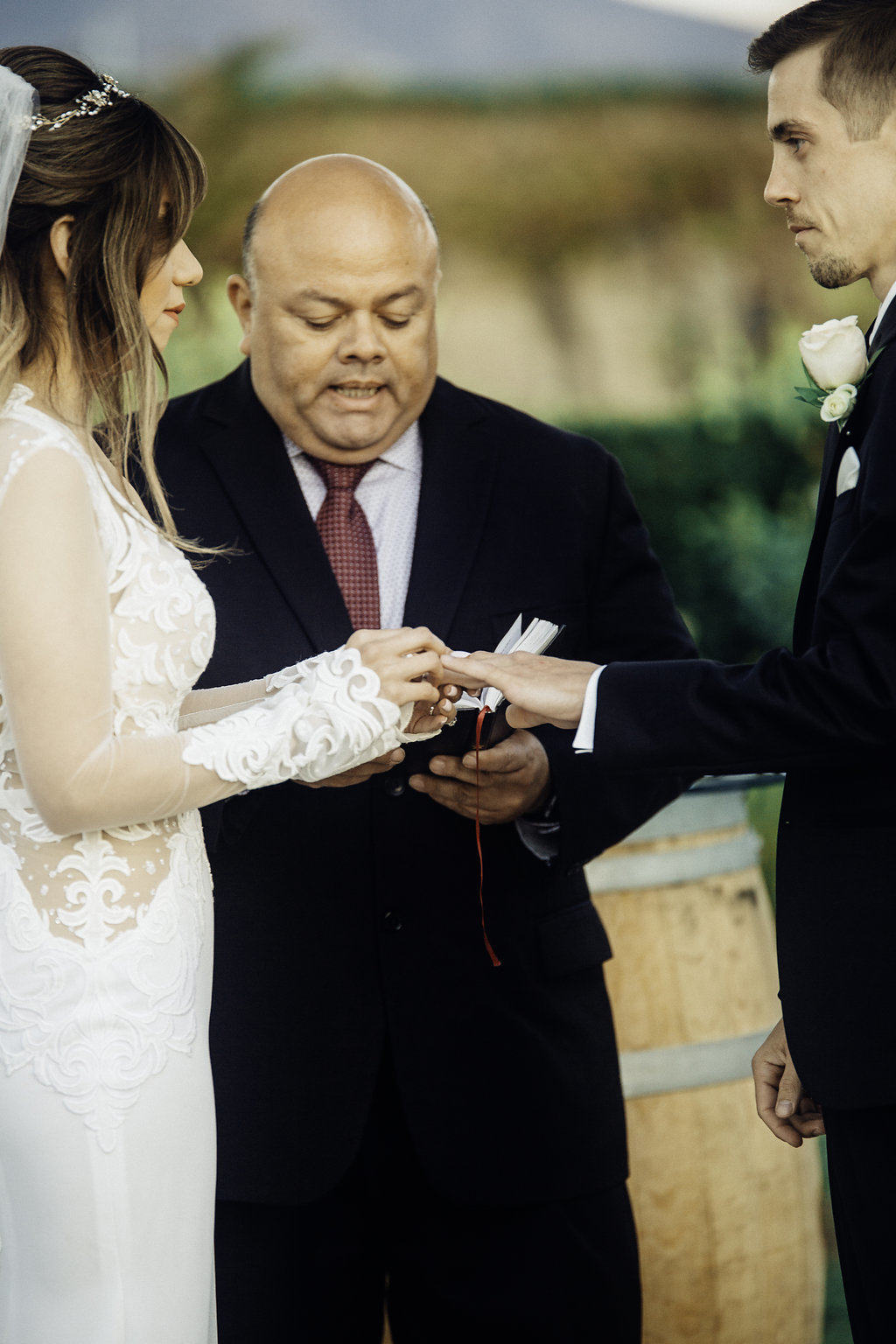 Wedding Photograph Of Bride Looking at Her Groom While Giving The Ring Los Angeles