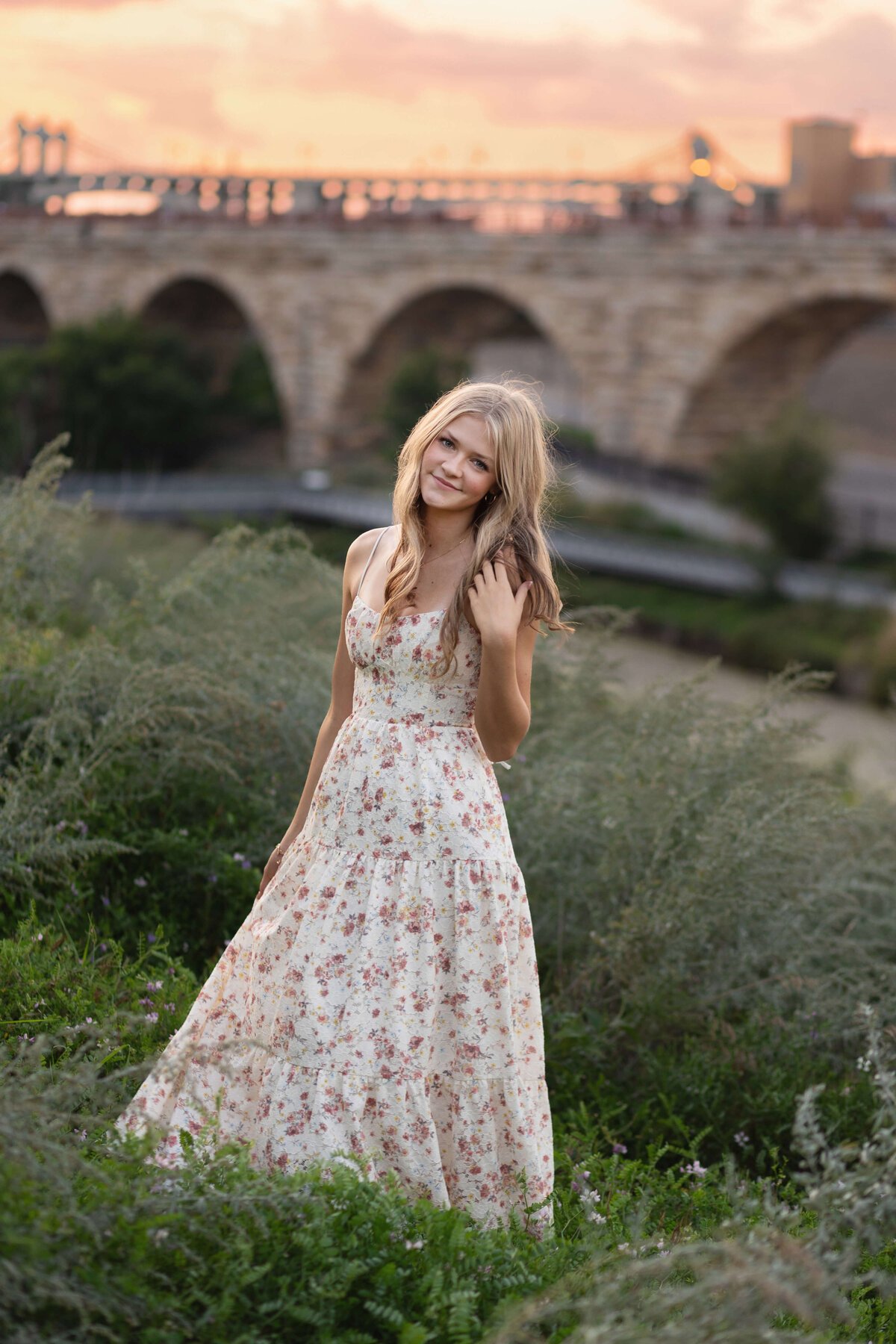 girl smiling with stone arch bridge in background