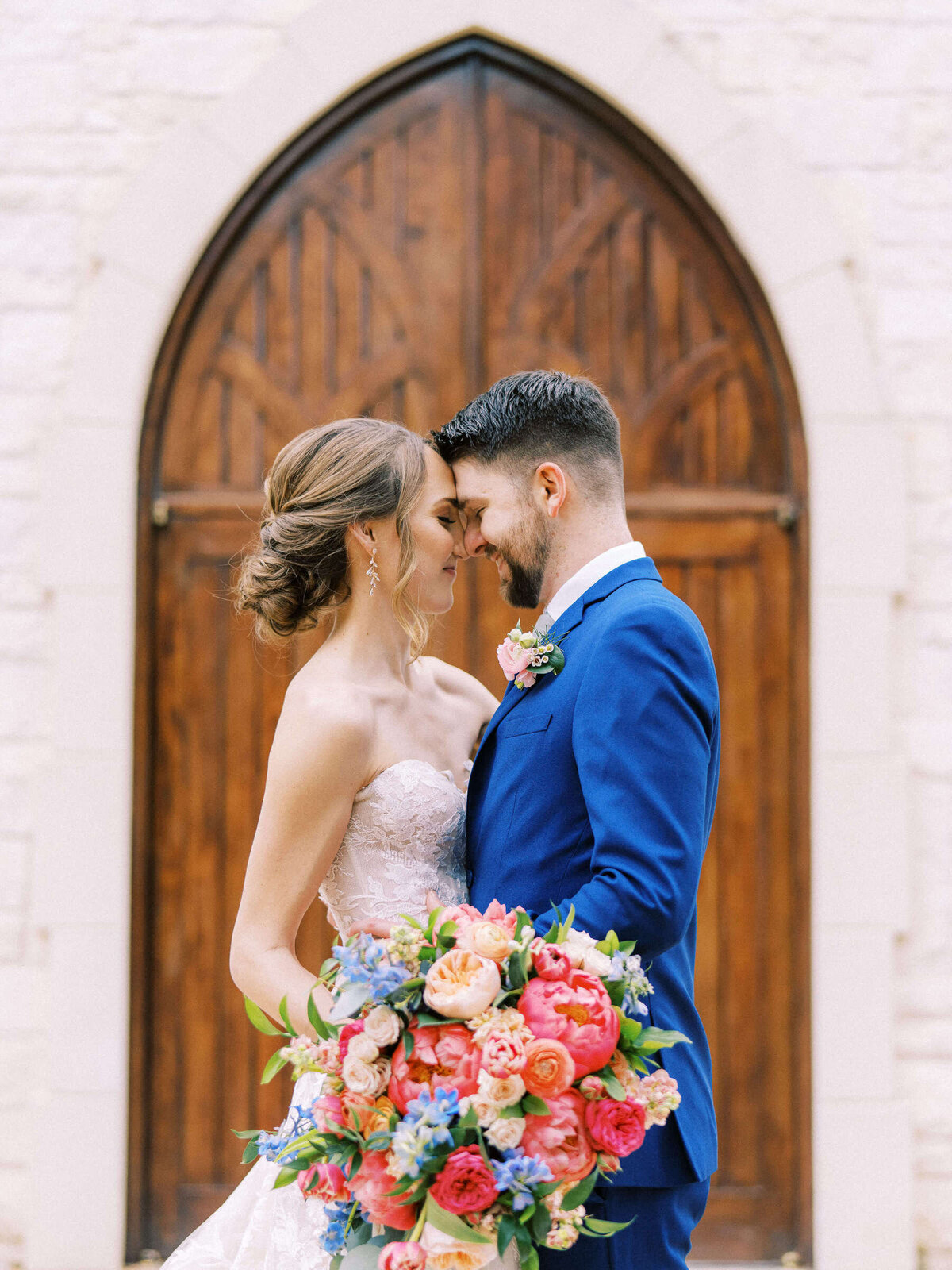 Bride and groom at Ashton Gardens wedding chapel with colorful bouquet