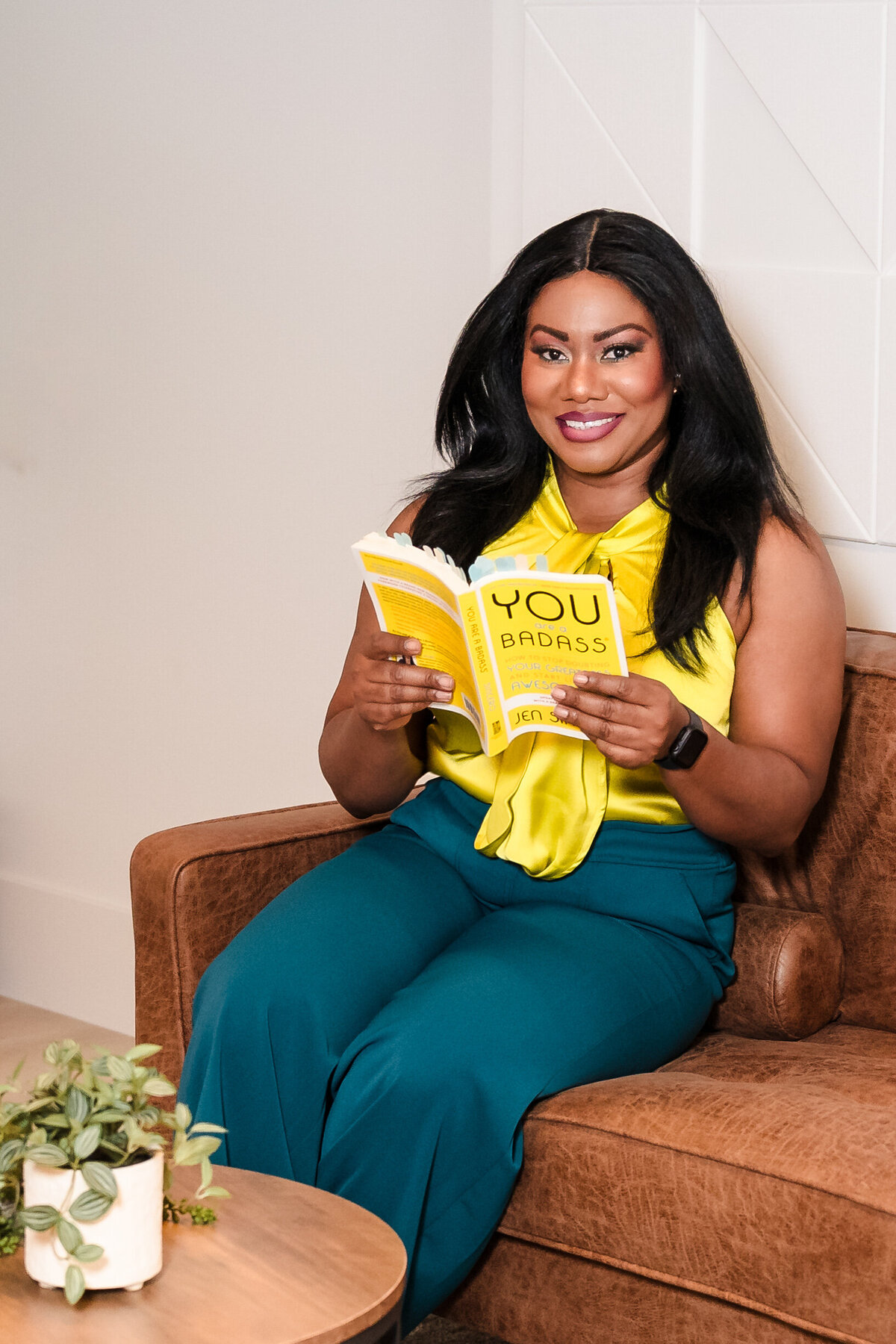 brand photo of a Woman posing confidently with  a empowerment book
