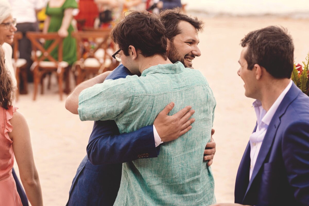 Brother hugs groom at Blue Venado Seaside Riviera Maya wedding