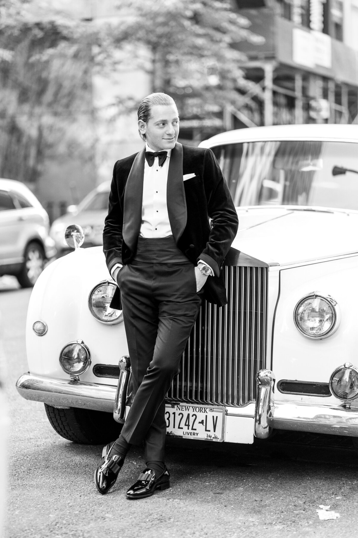 groom standing  with limo