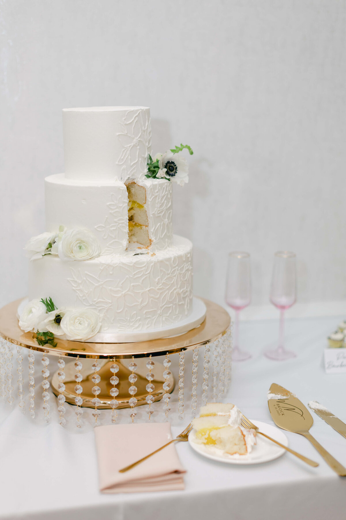 A cake sits on a golden platter with a piece cut out of it.
