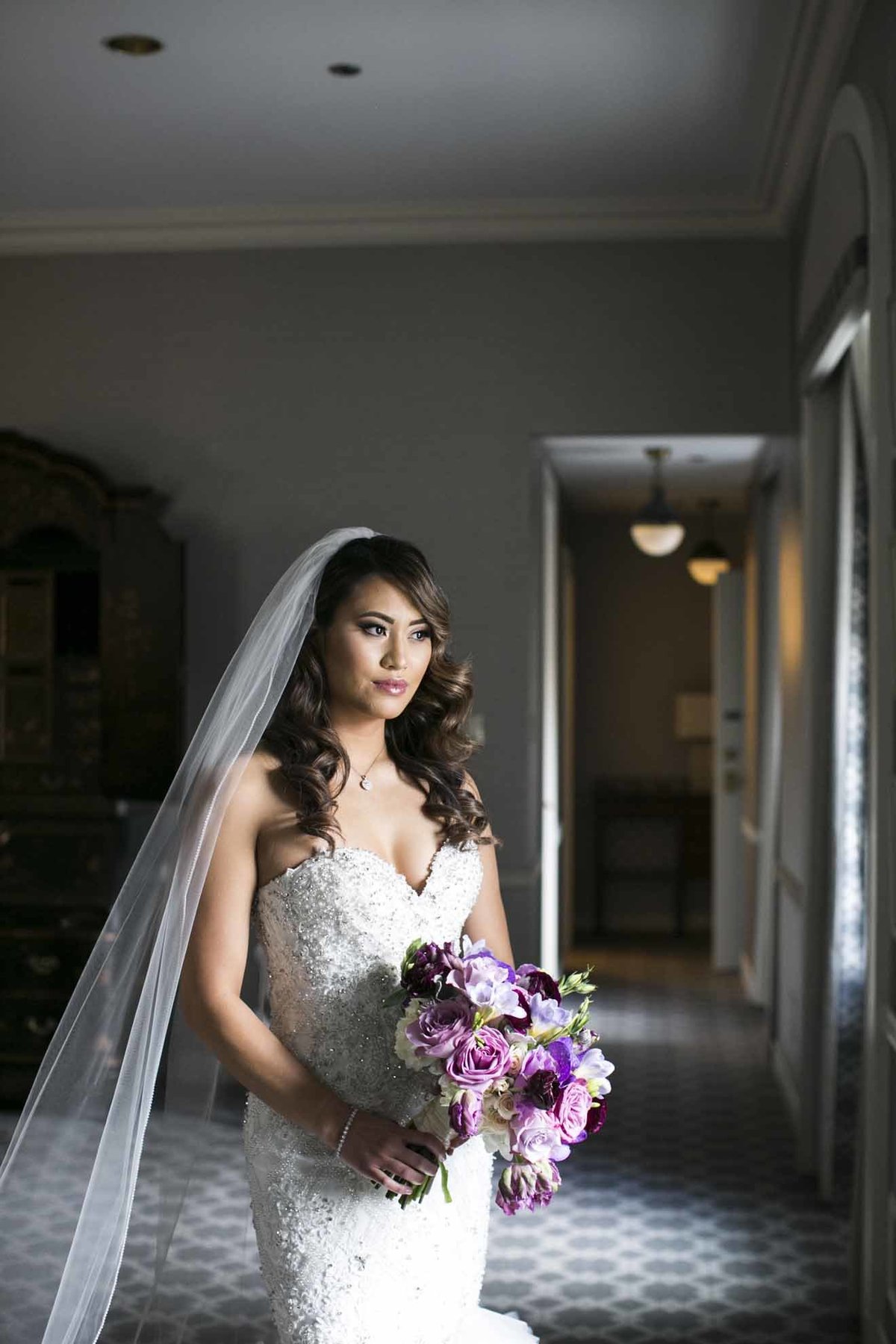Our beautiful bride Mara holding a purple bridal bouquet.