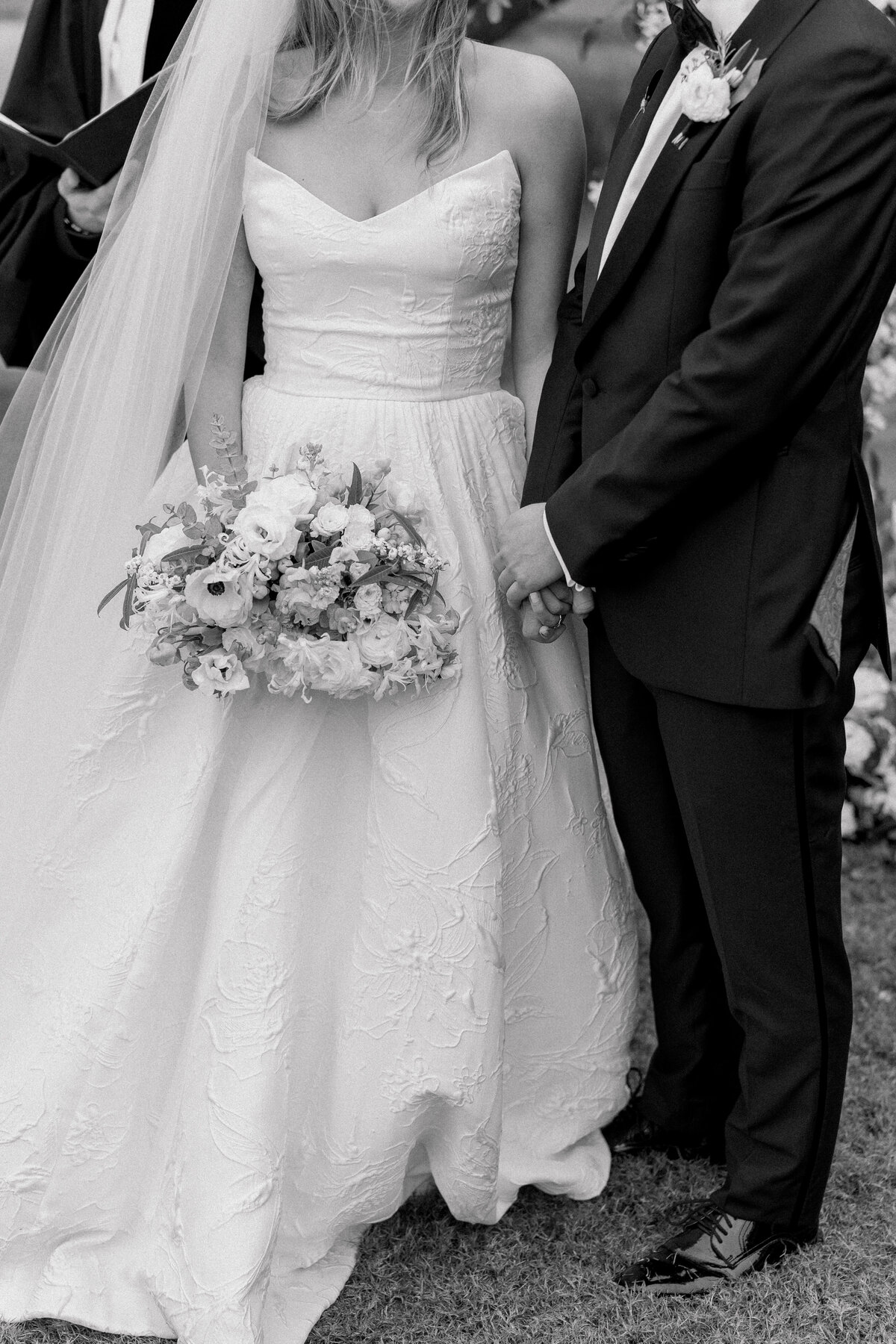 Intimate black and white photo of bride and  groom holding hands during wedding ceremony. Black and white photo. Kailee DiMeglio Photography. Charleston wedding photographer.