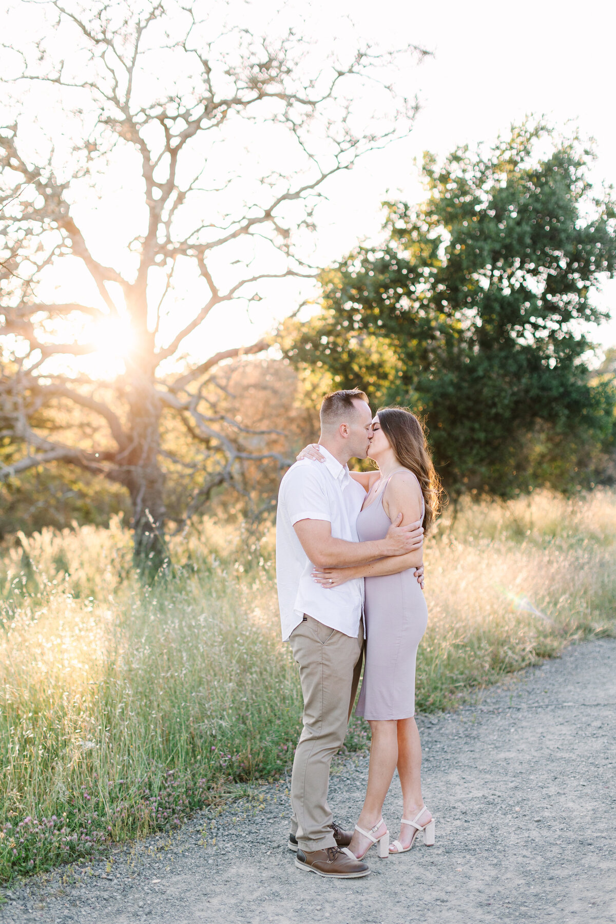 engaged couple kissing on a nature trail in sonoma county.