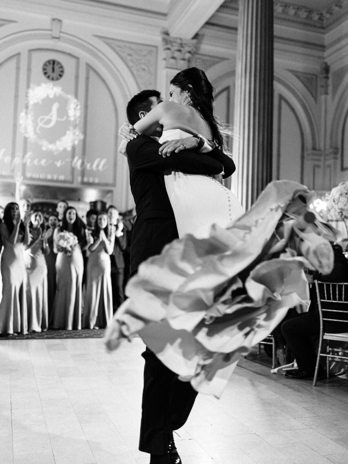 Black and white photo of groom spinning and lifting the bride during their wedding at The Vault in St. Augustine.