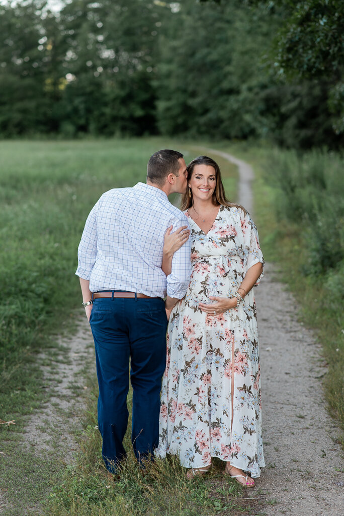 Dad kissing mom, while mom smiles at camera with hand on pregnant stomach | Sharon Leger Photography | CT Newborn & Family Photographer | Canton, Connecticut