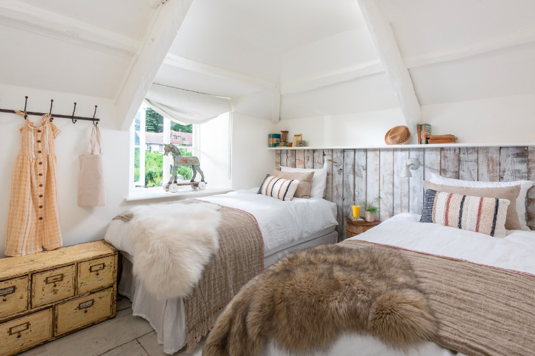 Twin kids room with animal fur blankets and wooden panelling