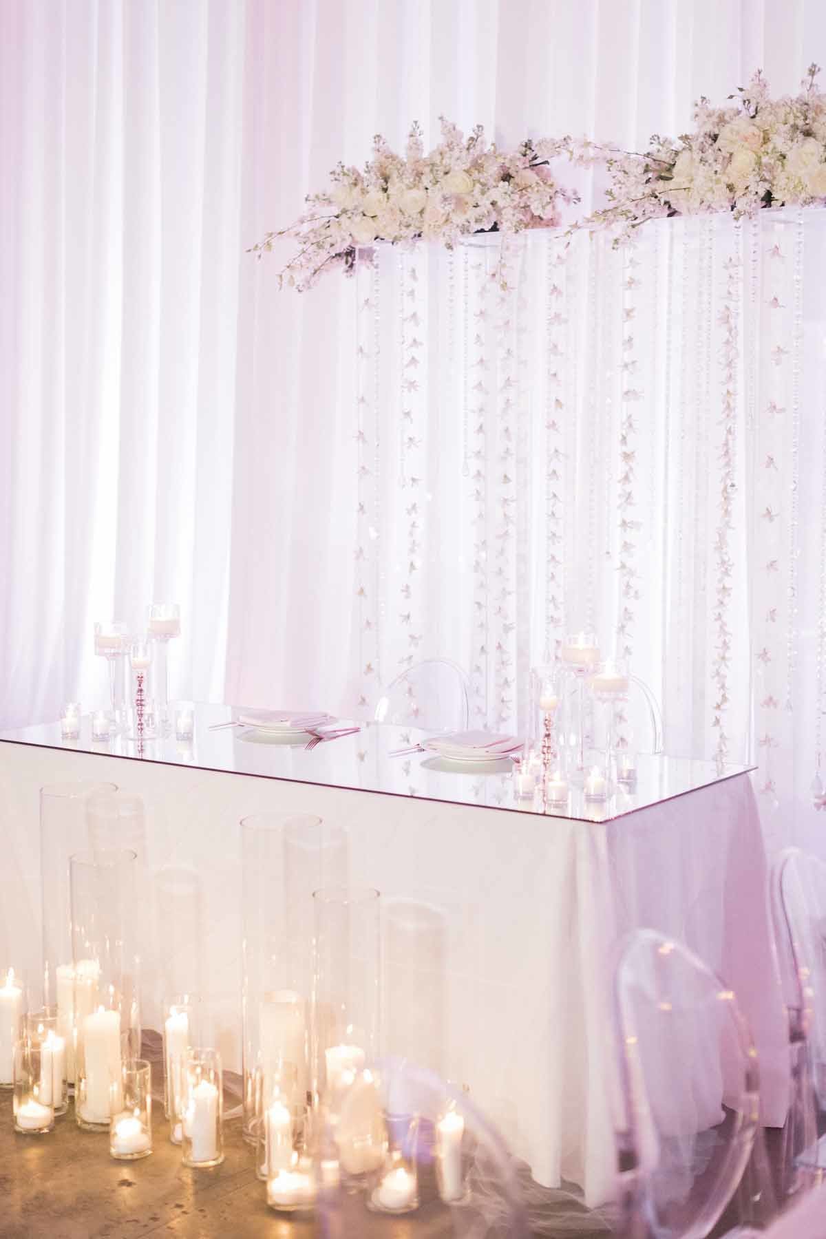 Head table framed by the wedding ceremony arch or white orchids