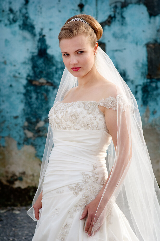 Bride with brown hair wearing tiara and veil with a Greek style wedding dress layered with sequins