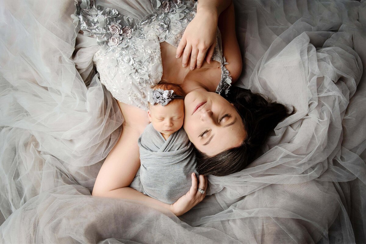st-louis-newborn-photographer-mom-in-gray-gown-laying-with-baby