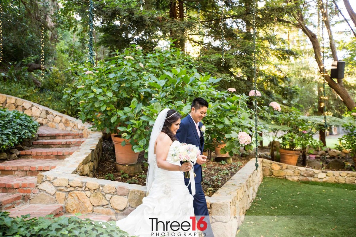 Bride and Groom exit the ceremony area through rock walls and stone steps at Calamigos Ranch