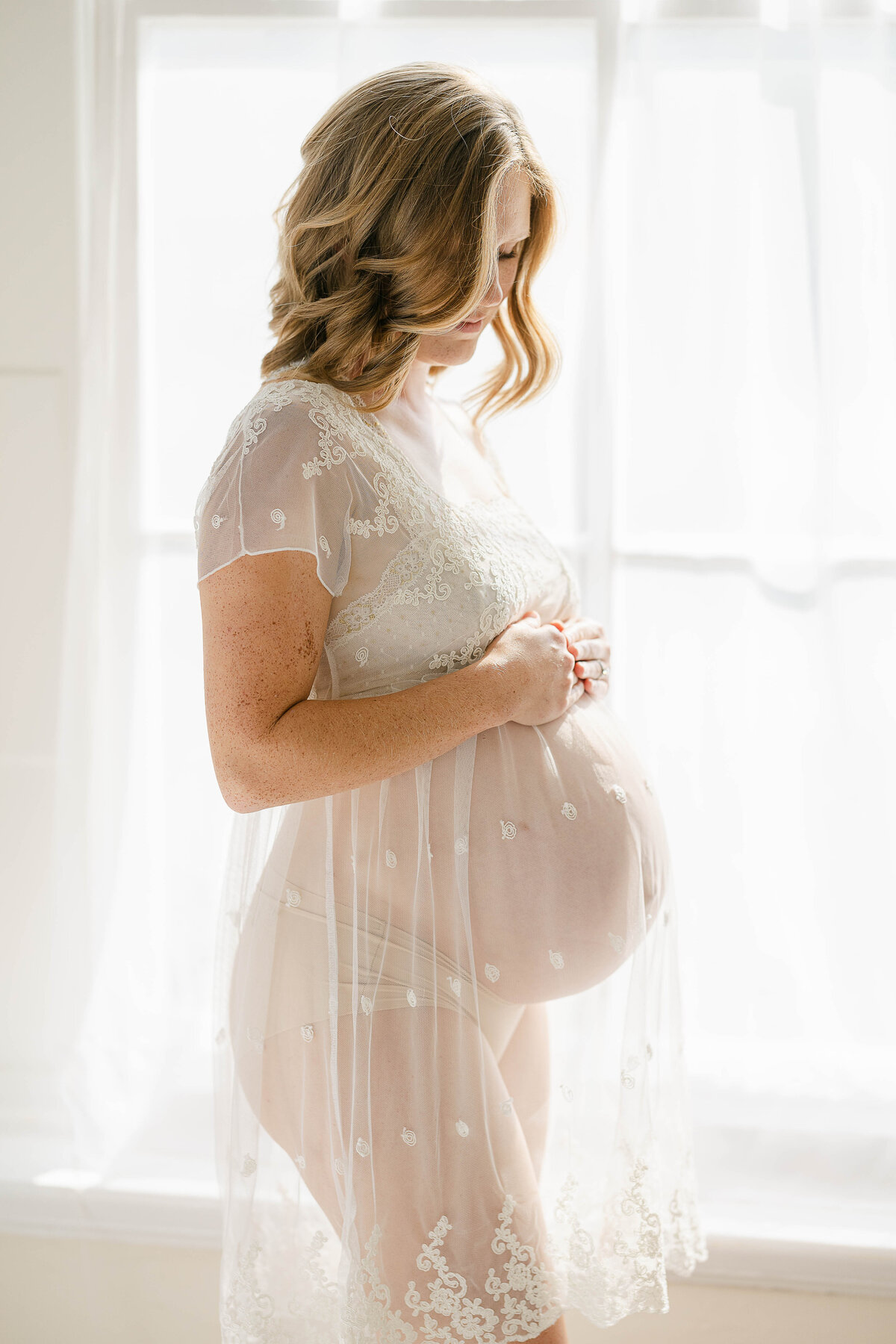 Portrait of pregnant woman in a see-through dress