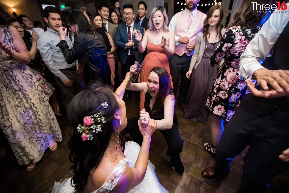 Bride dances with a female guest during the reception