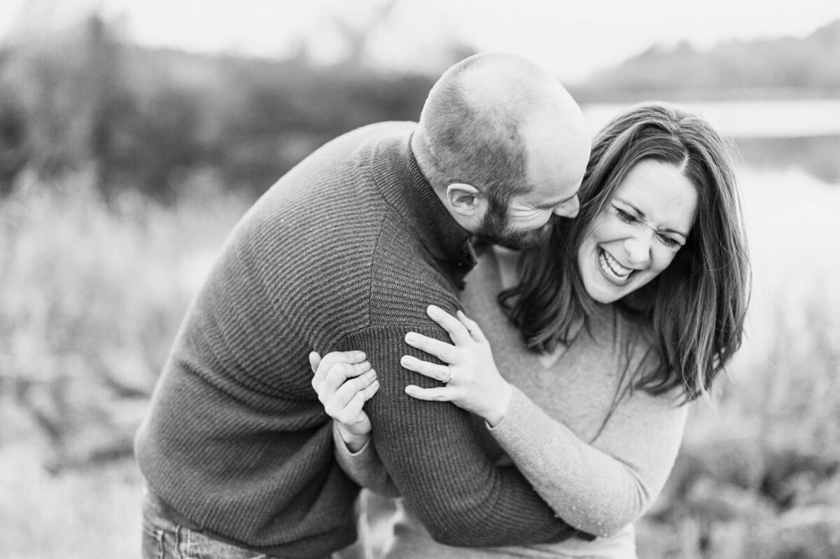 Playful married couple laughing together at a couples session at Busse Woods near Chicago,.