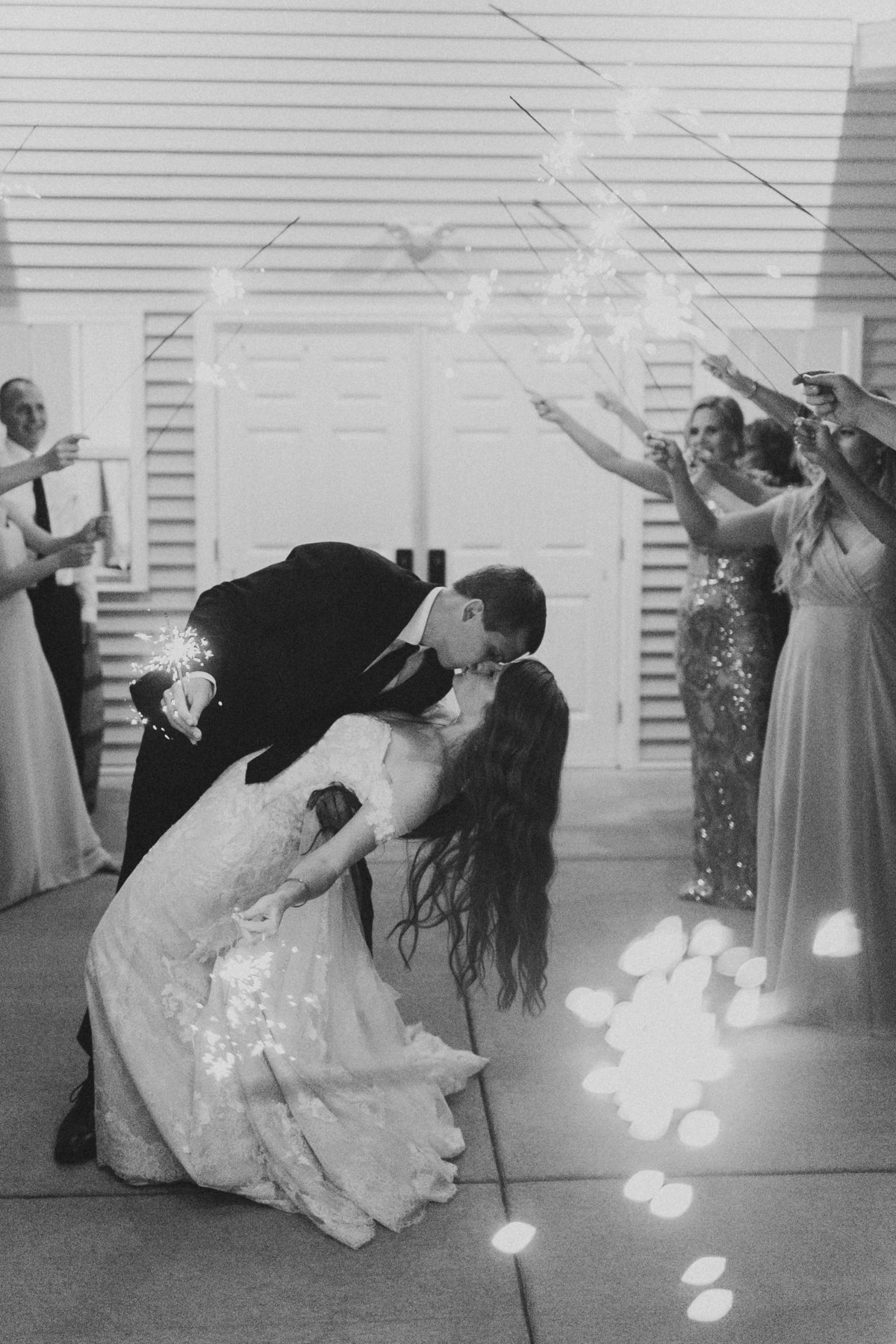 couple kissing during sparkler wedding exit