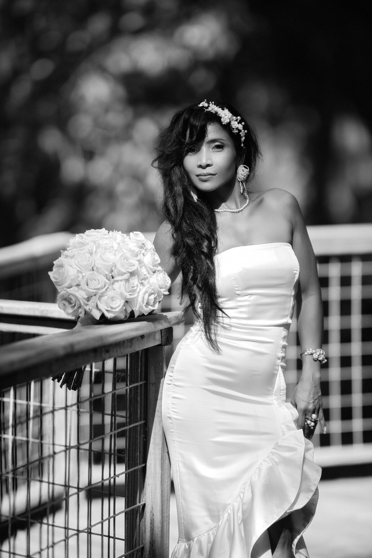 bride in tight wedding dress posing with flowers for pictures by gg