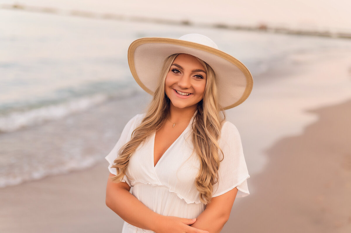 A female student from New Berlin West High School poses along the shoreline while her portrait is taken.