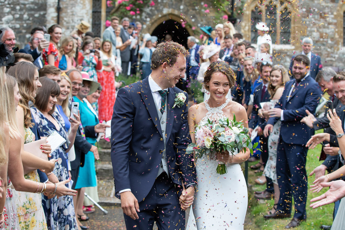 Bride and Groom with confetti at Huntsham Court Wedding Devon_