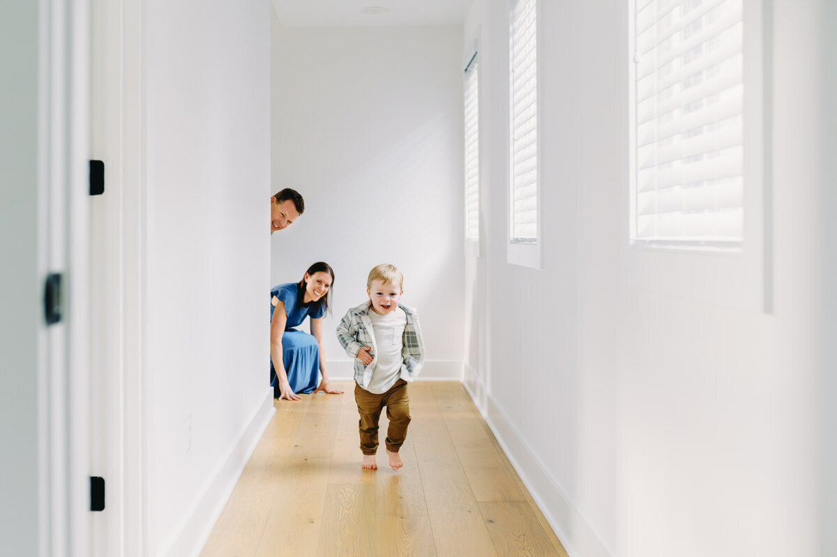 little boy running in hallway with parents looking on photographed by NPS Photography
