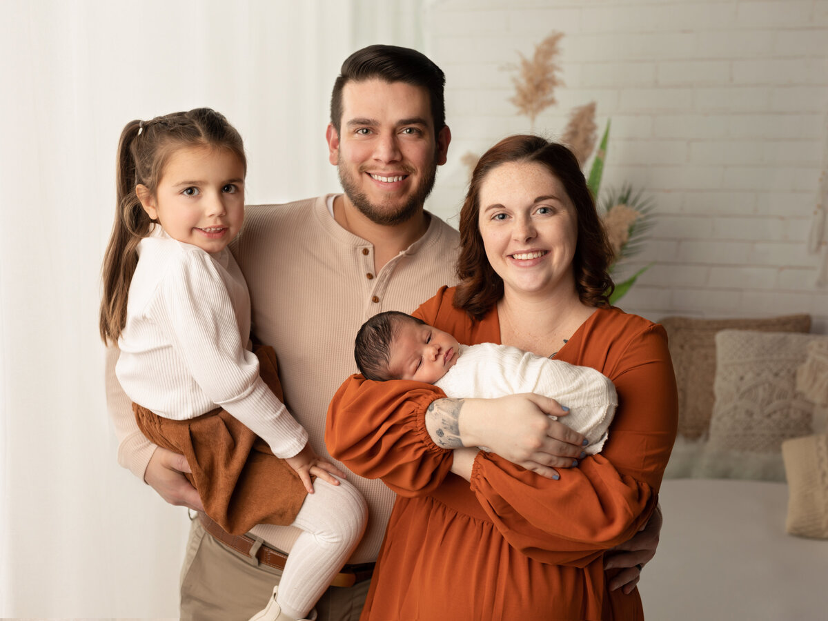family hodling newborn son for boho style photoshoot cleveland newborn photographer