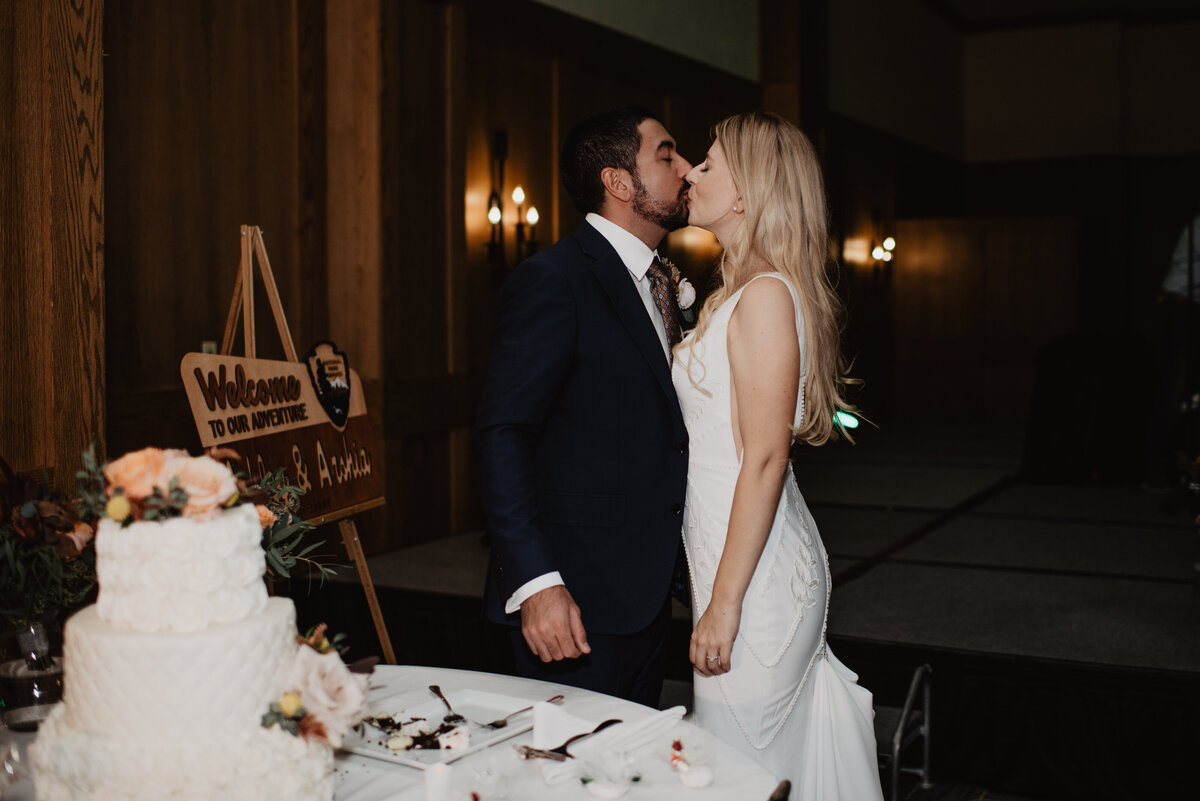 Photographers Jackson Hole capture couple kissing after cake cutting