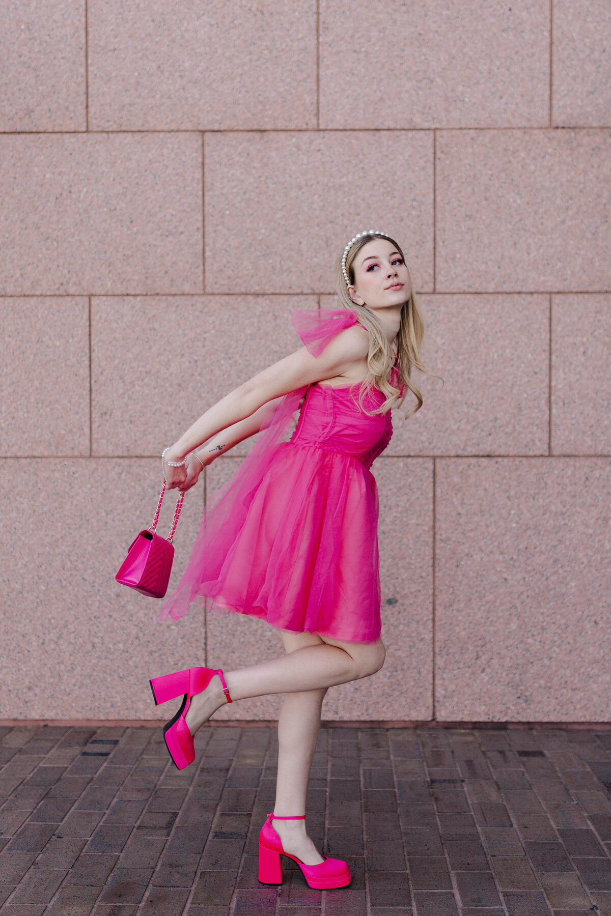 model poses as weird barbie in all hot pink in front of galleria tiffanys in houston