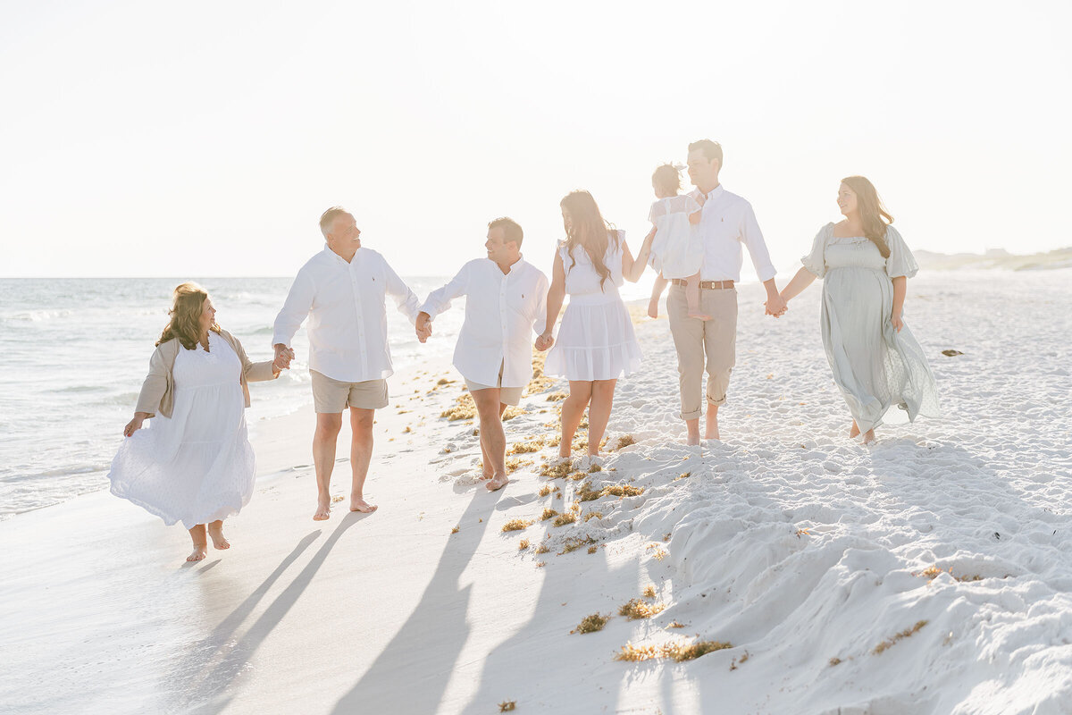 A destin family enjoying beach photography and bonding while holding hands.