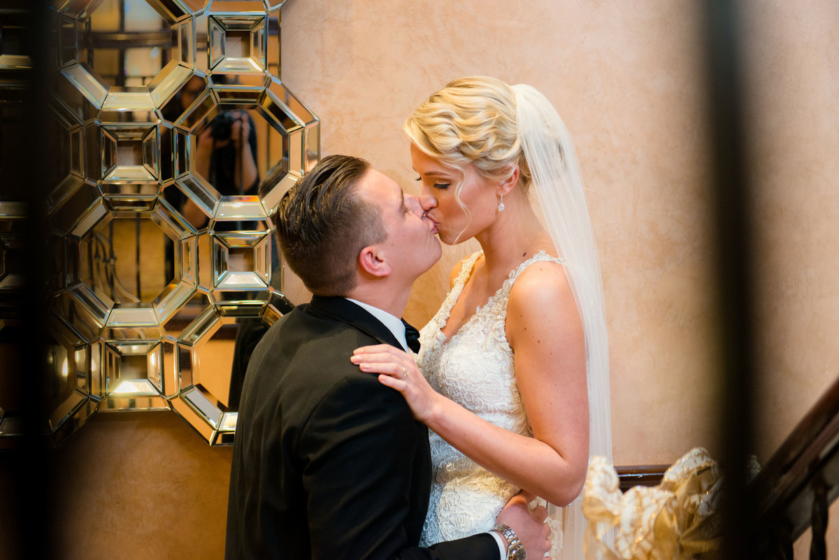 Bride and groom kissing on steps at The Inn at Fox Hollow