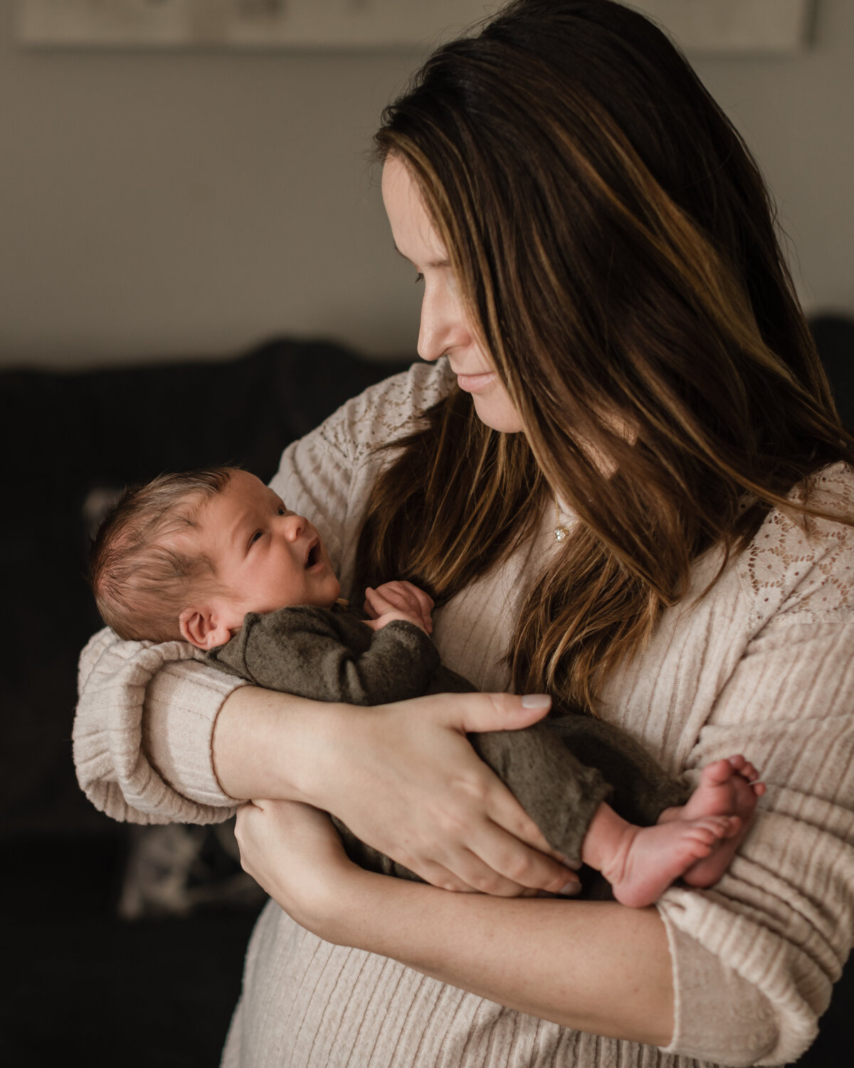 mom holding newborn baby son for in home lifestyle photography session
