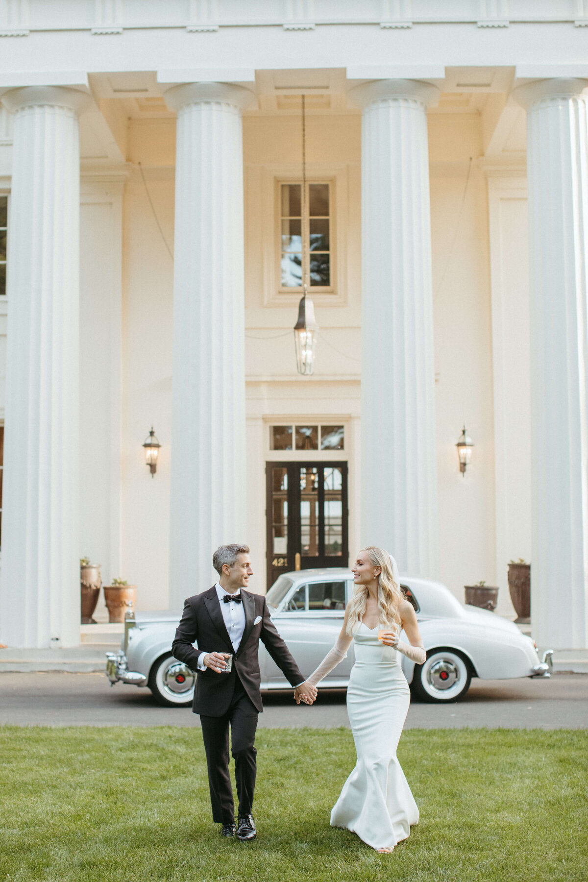 bride and groom holding hands in front of wadsworth mansion