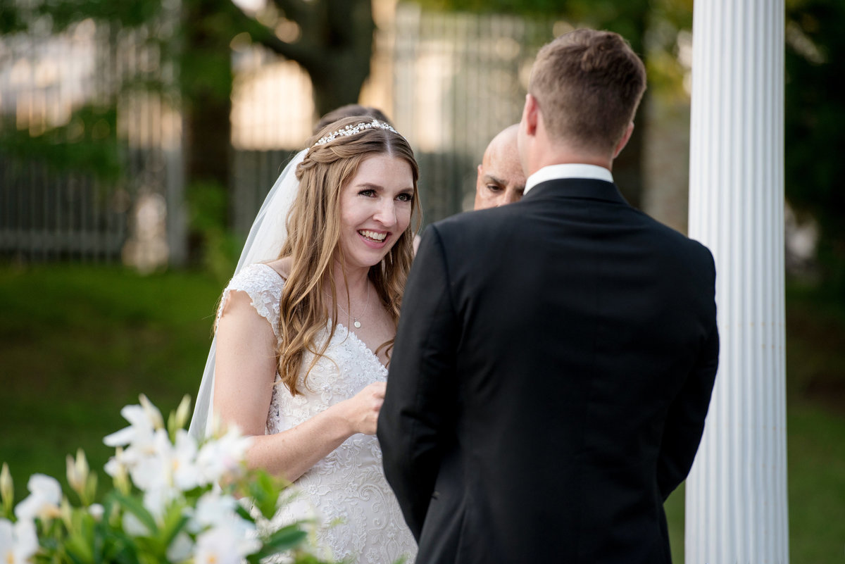 bride smiling at groom during outdoor wedding ceremony at Willow Creek Golf and Country Club