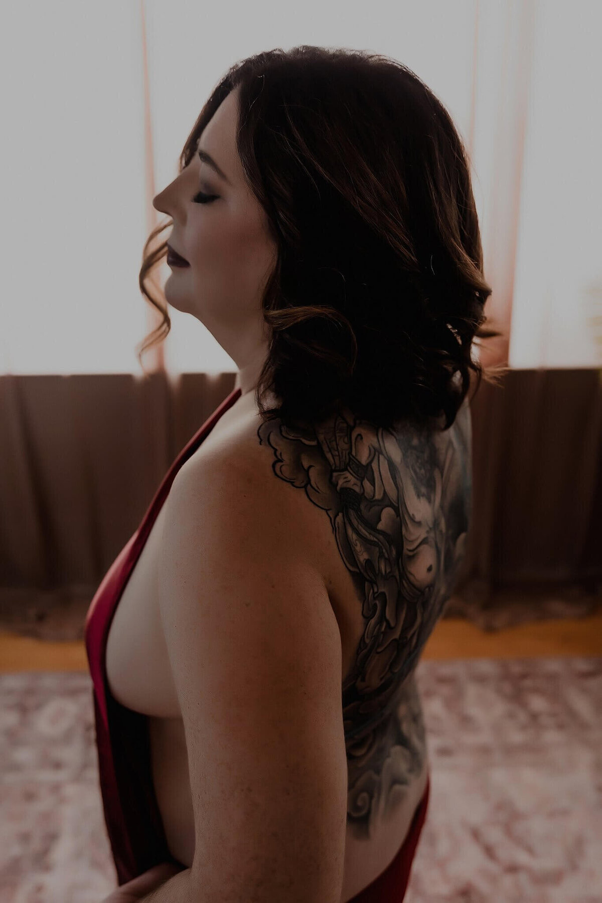 woman wrapped in a sheet with open back showing tattoo