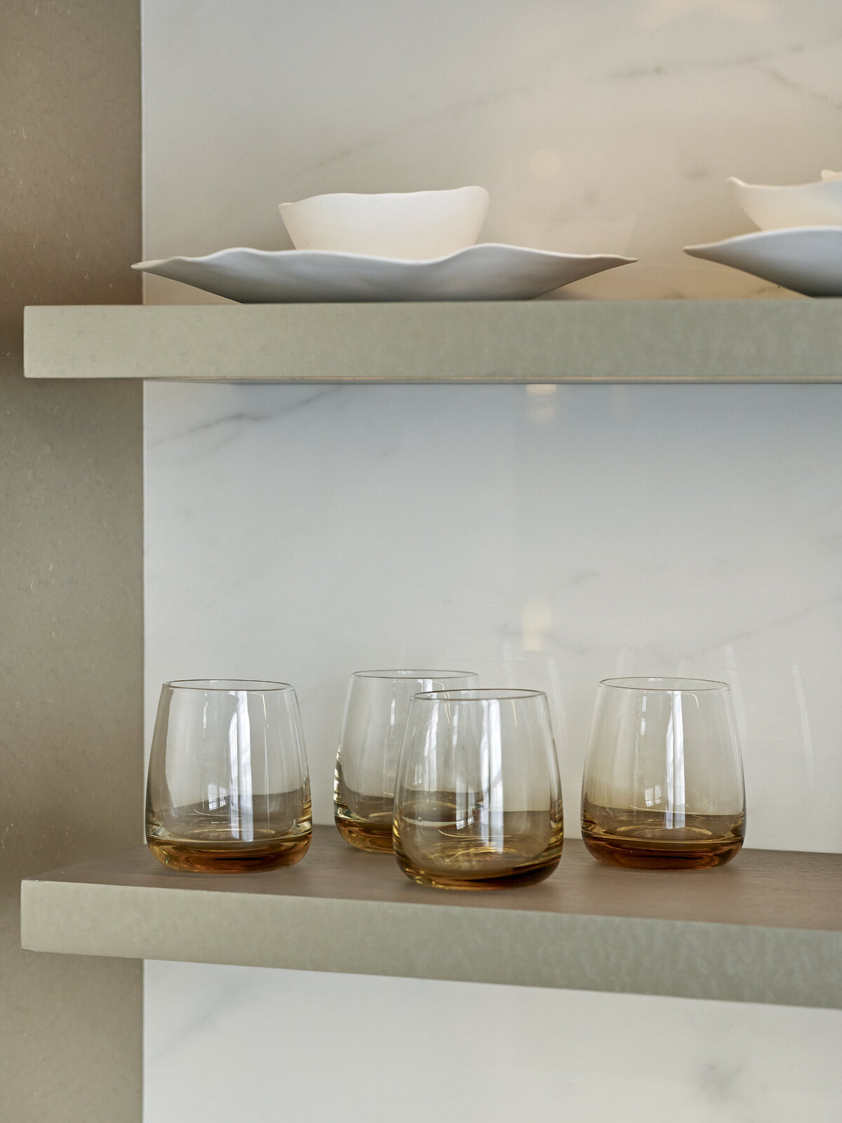 four modern glasses and on open shelving