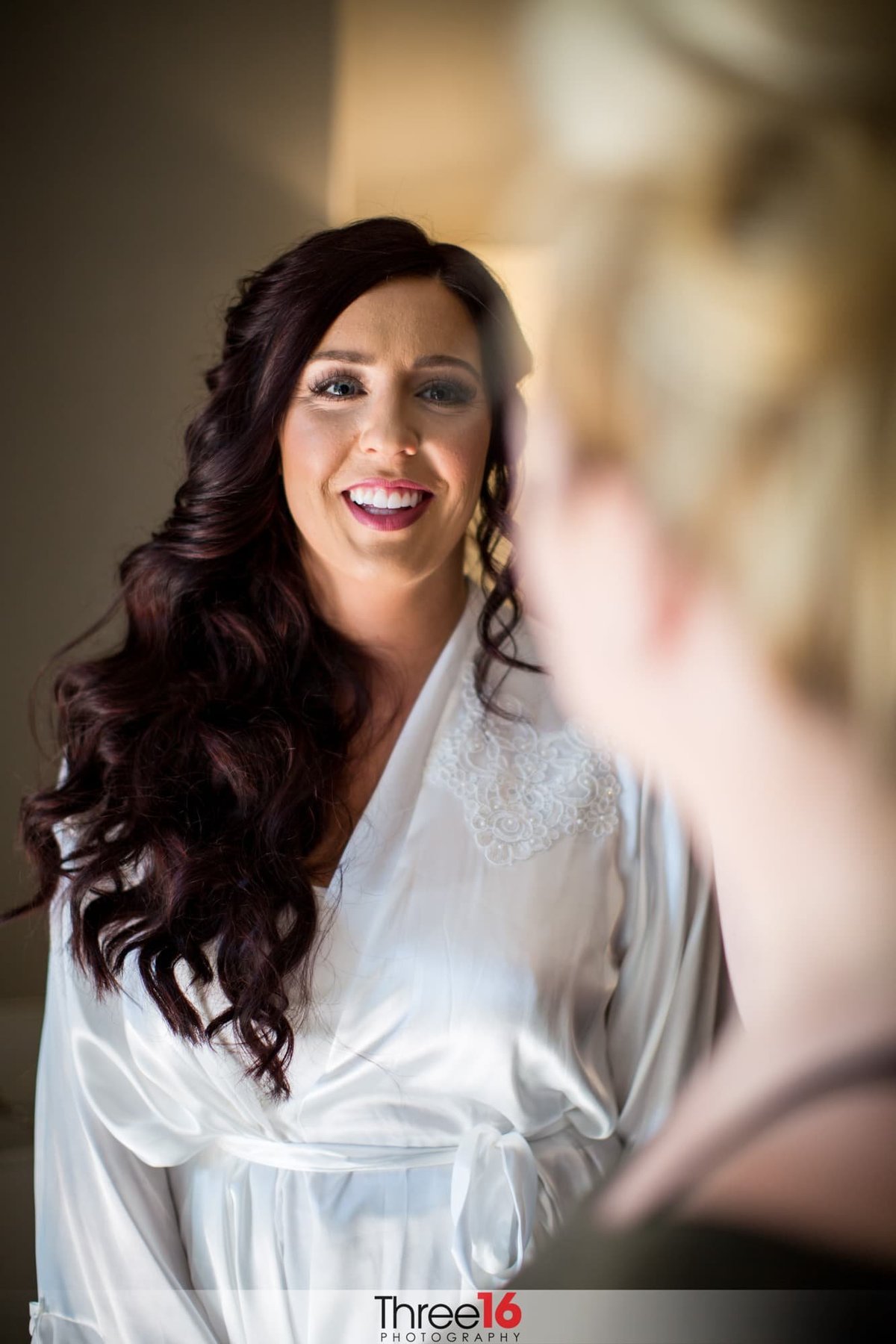 Bride smiling to the camera prior to getting dressed for her wedding