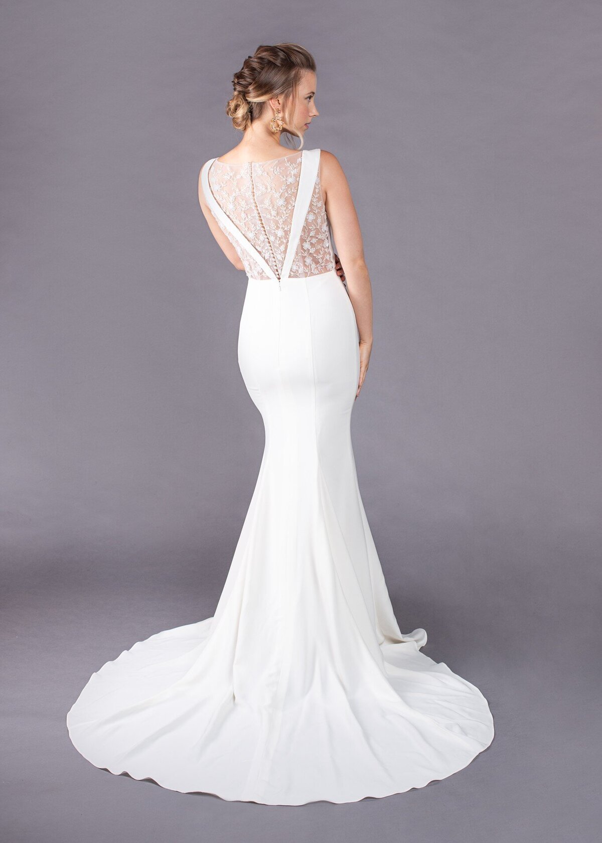 The embroidered illusion back is paired with the crepe fit-and-flare skirt for a unique yet timeless bridal look.