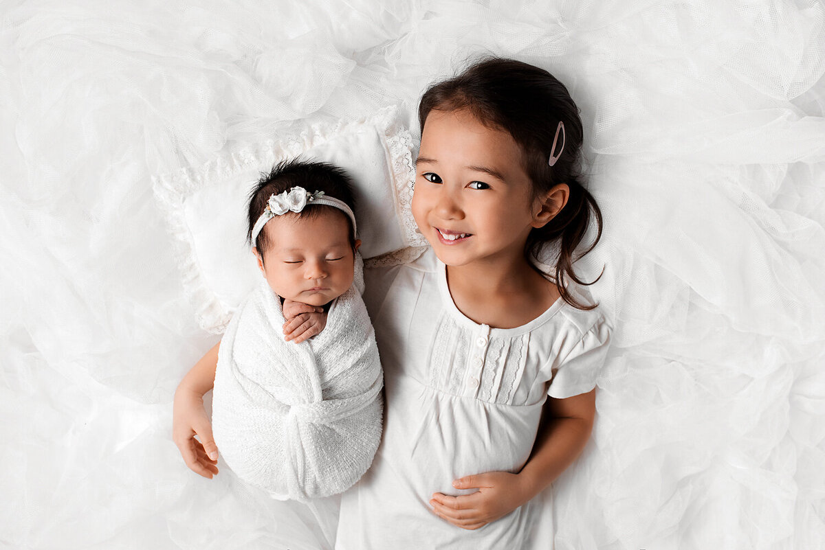 Newborn baby session with newborn girl and older sister.