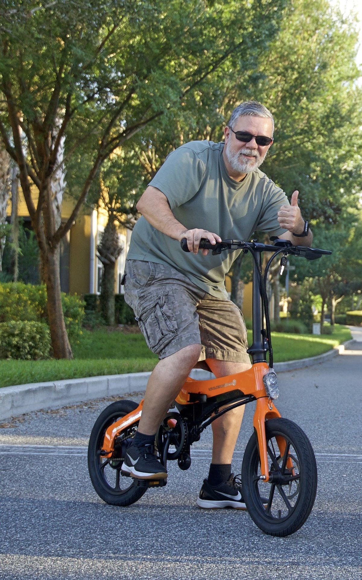 Man giving thumbs up on Orange Go-Bike M4; V&D Electric Bikes