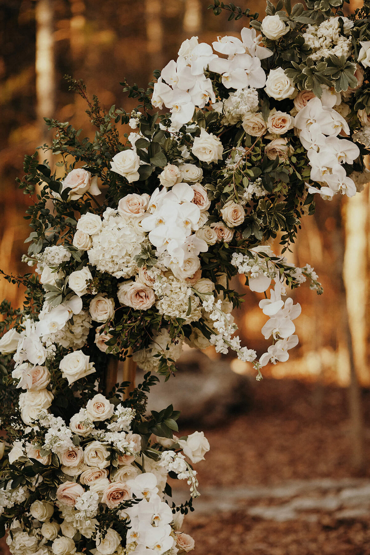 white, champagne, blush flowers and greenery on hay bale ceremony altar