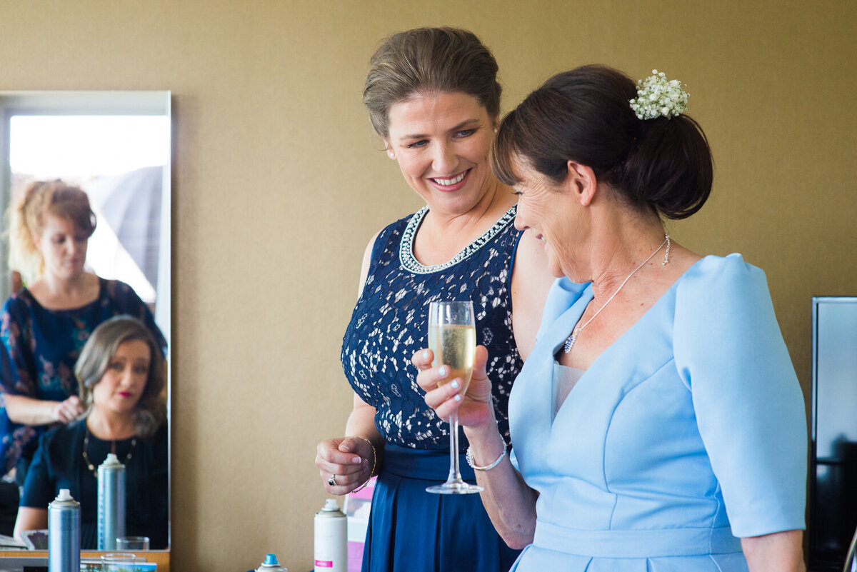Gay bride looking at Mum in law at wedding preparations