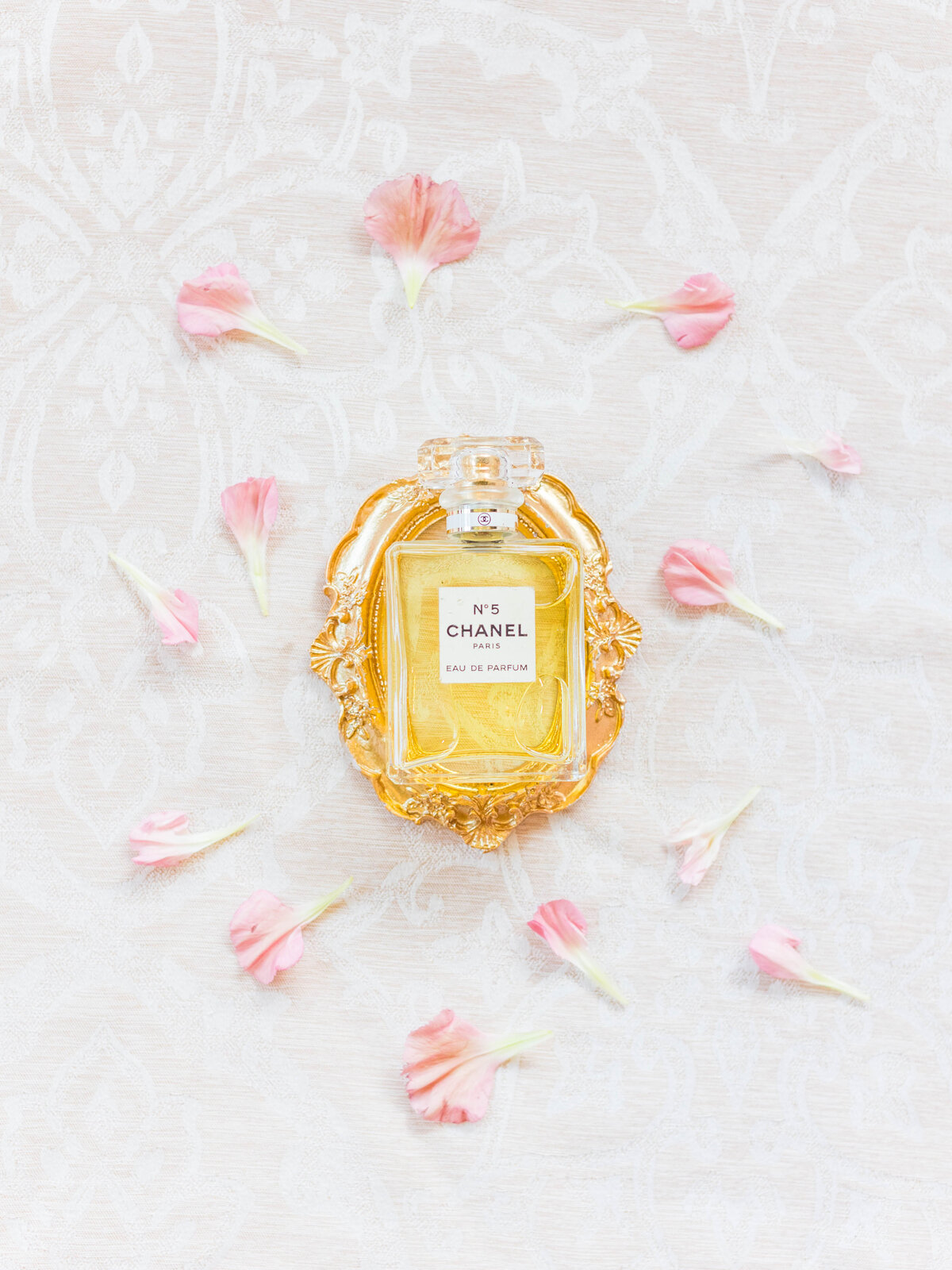chanel perfume bottle styled with pink florals