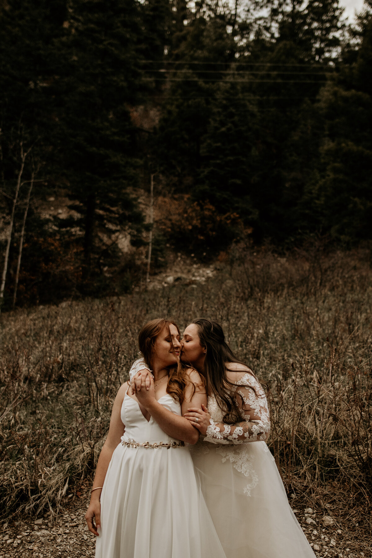bride holding wife from behind after wedding