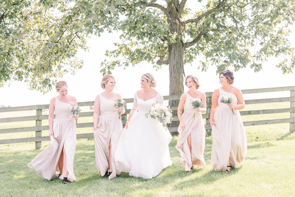 bridesmaids walking and laughing on a wedding day at Ardon Creek winery in Letts, Iowa
