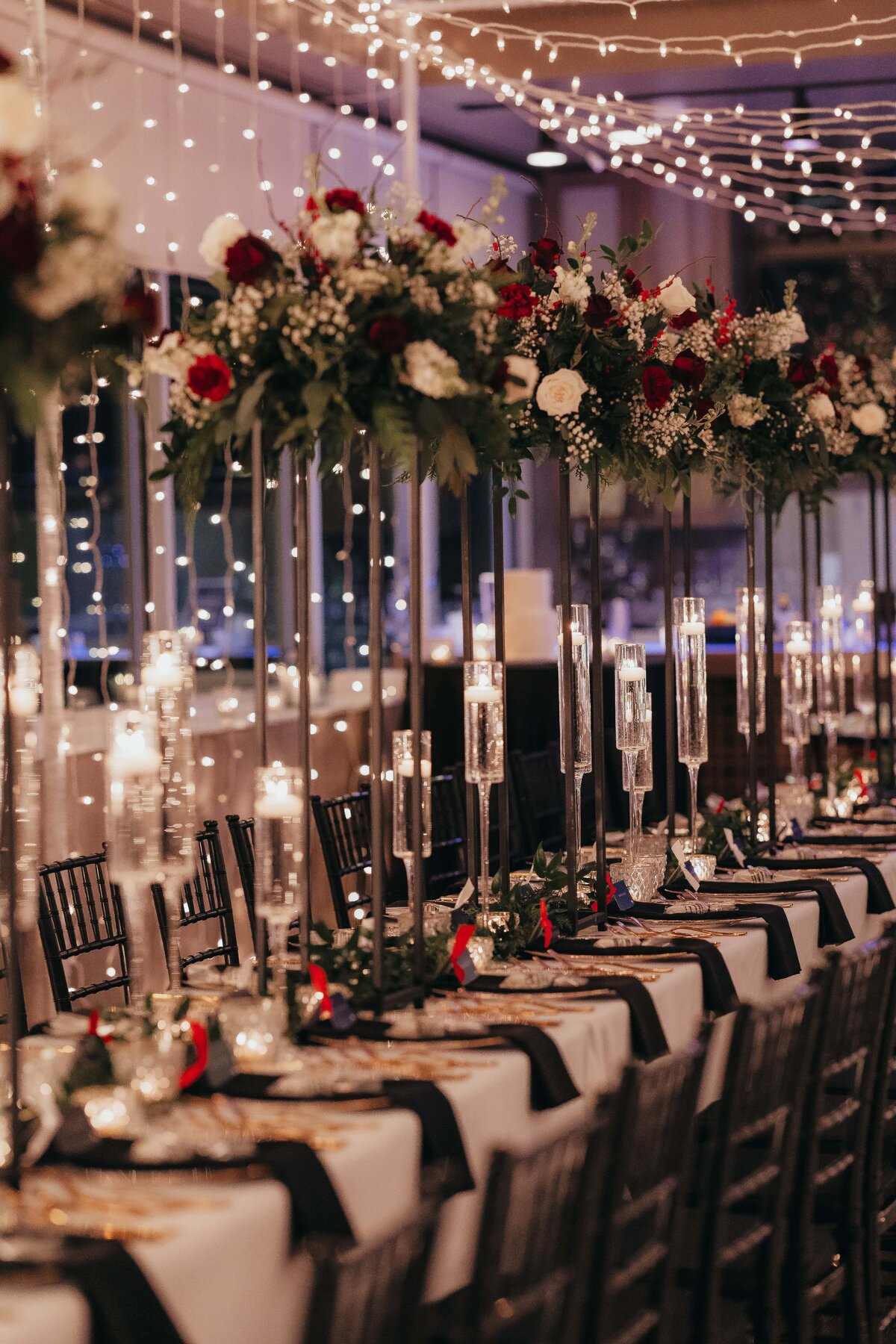 Elegant Iowa weddings reception table with floral centerpieces and candles under string lights, creating a romantic ambiance.