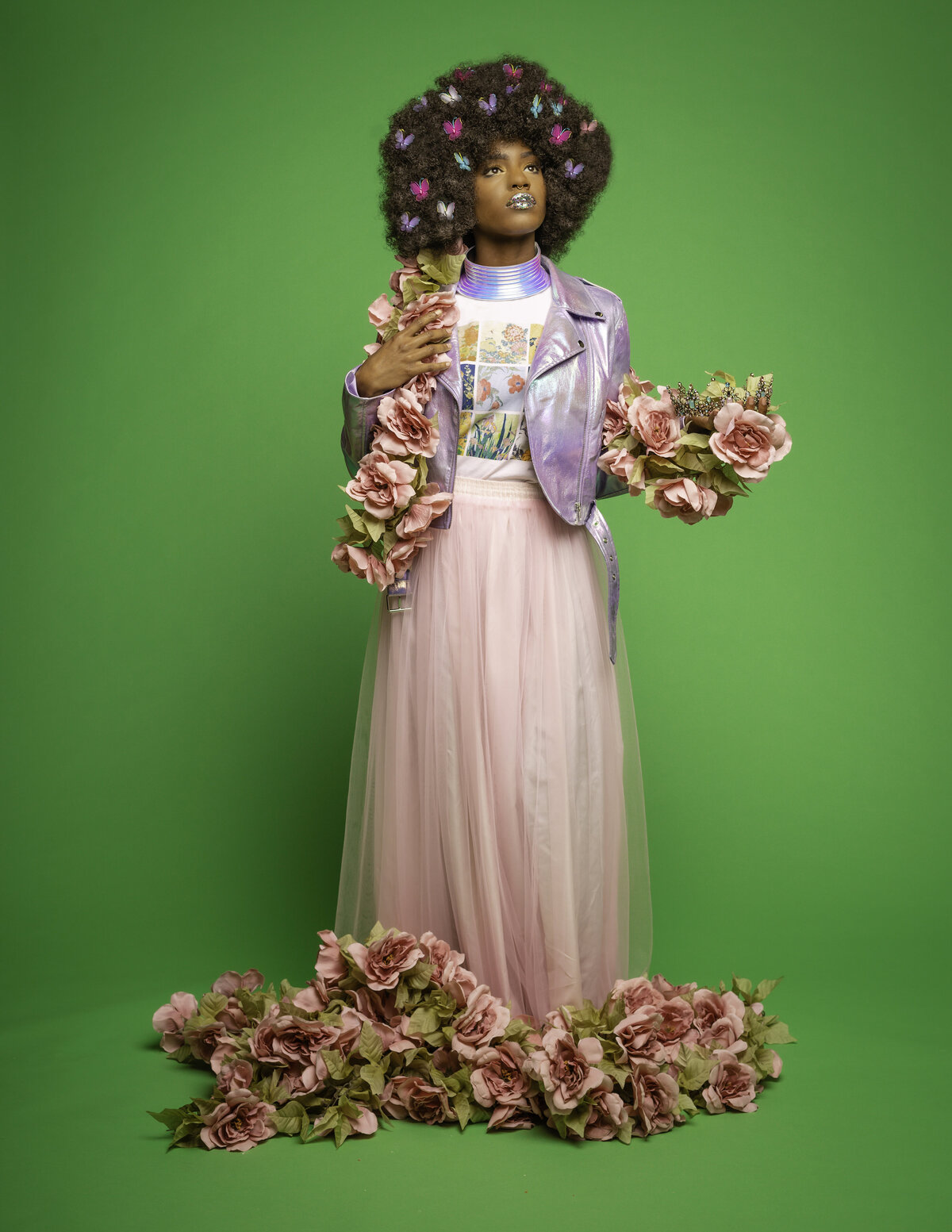 Black woman with afro in purple jacket and pink skirt with flowers