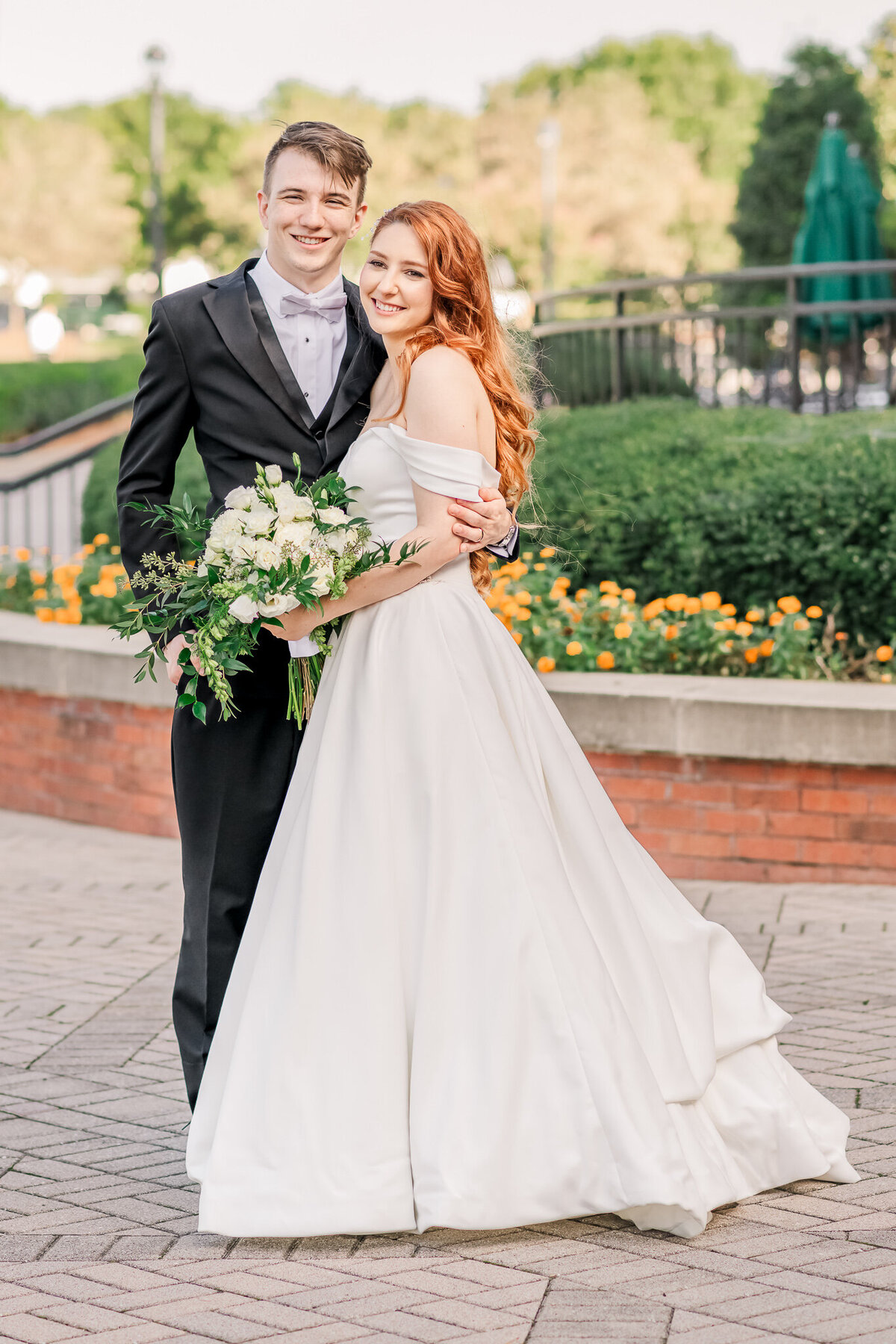 A smiling newly married couple enjoying their Raleigh wedding session of wedding portraits in Cary